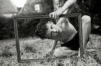 Cara Hodge's son looking through an antique picture frame in garden in france