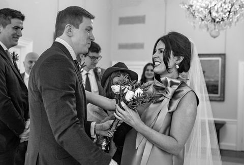 bride and groom meeting at the room to be married with family watching smiling bride