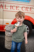 little boy eating ic cream in front of ice cream van