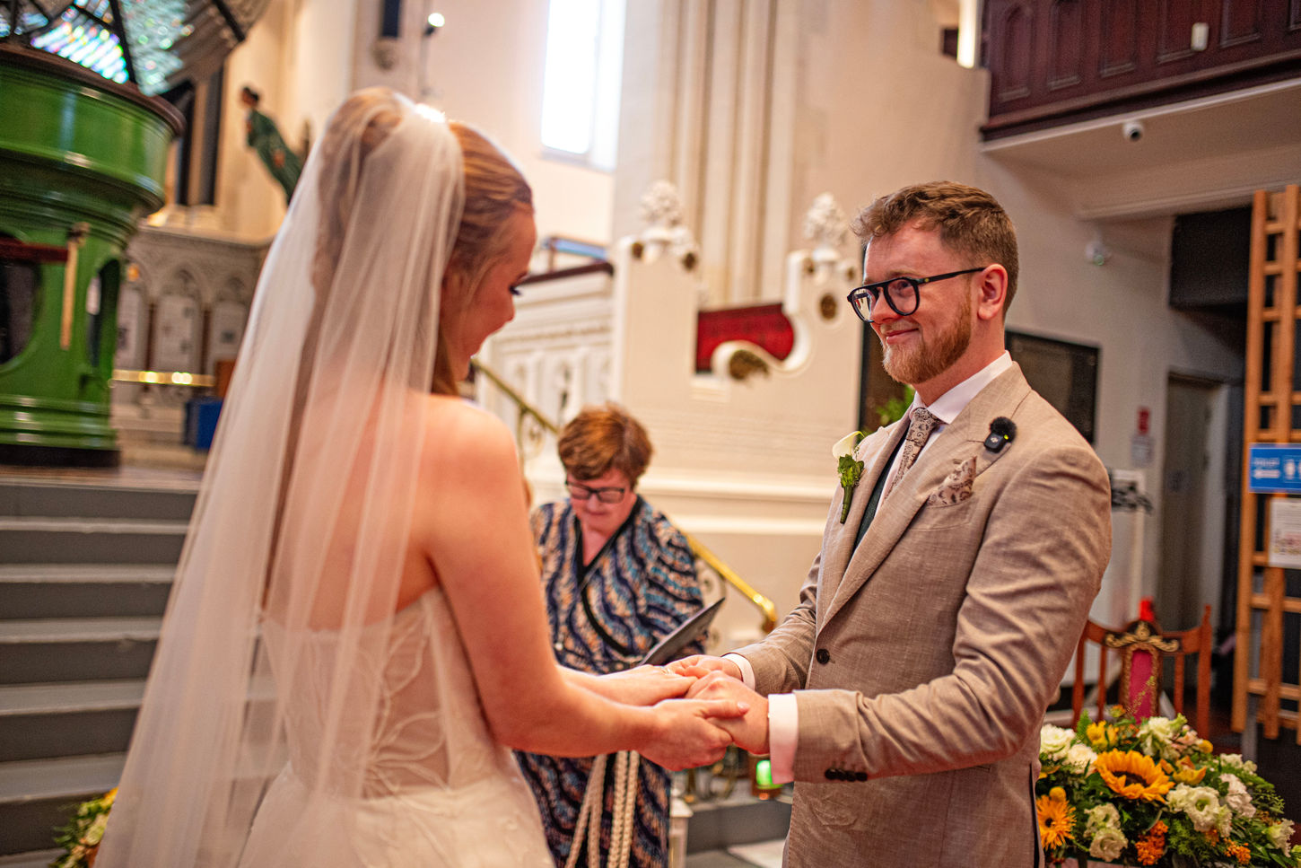 bride and groom holding hands in front of congregation