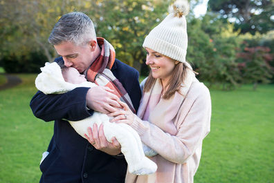 Father kissing newborn baby on forehead in dublin park