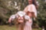mum swinging little girl in cotton dress