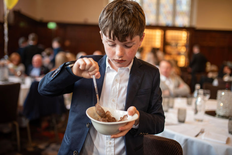 boy eating chocolate ice cream with chocolate around his mouth