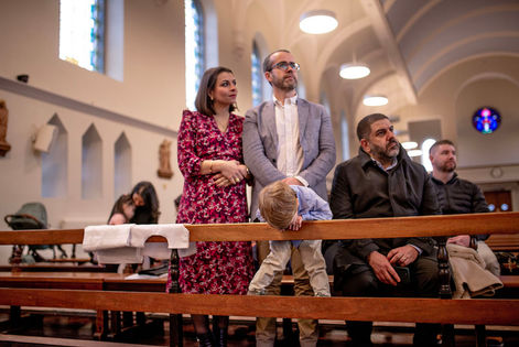boy leaning across church pews and head dangling down