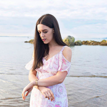young woman in pink sun dress on the beach at Seapoint, Dublin