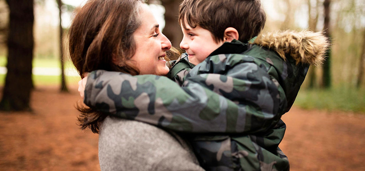 mum hugging her young son in killiney hill dublin. winter family photography dublin by cara. christmas family photo shoot outside in killiney hill. christmas family photo shoot Dublin