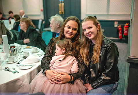 holding girl in white tutu at a table for lunch