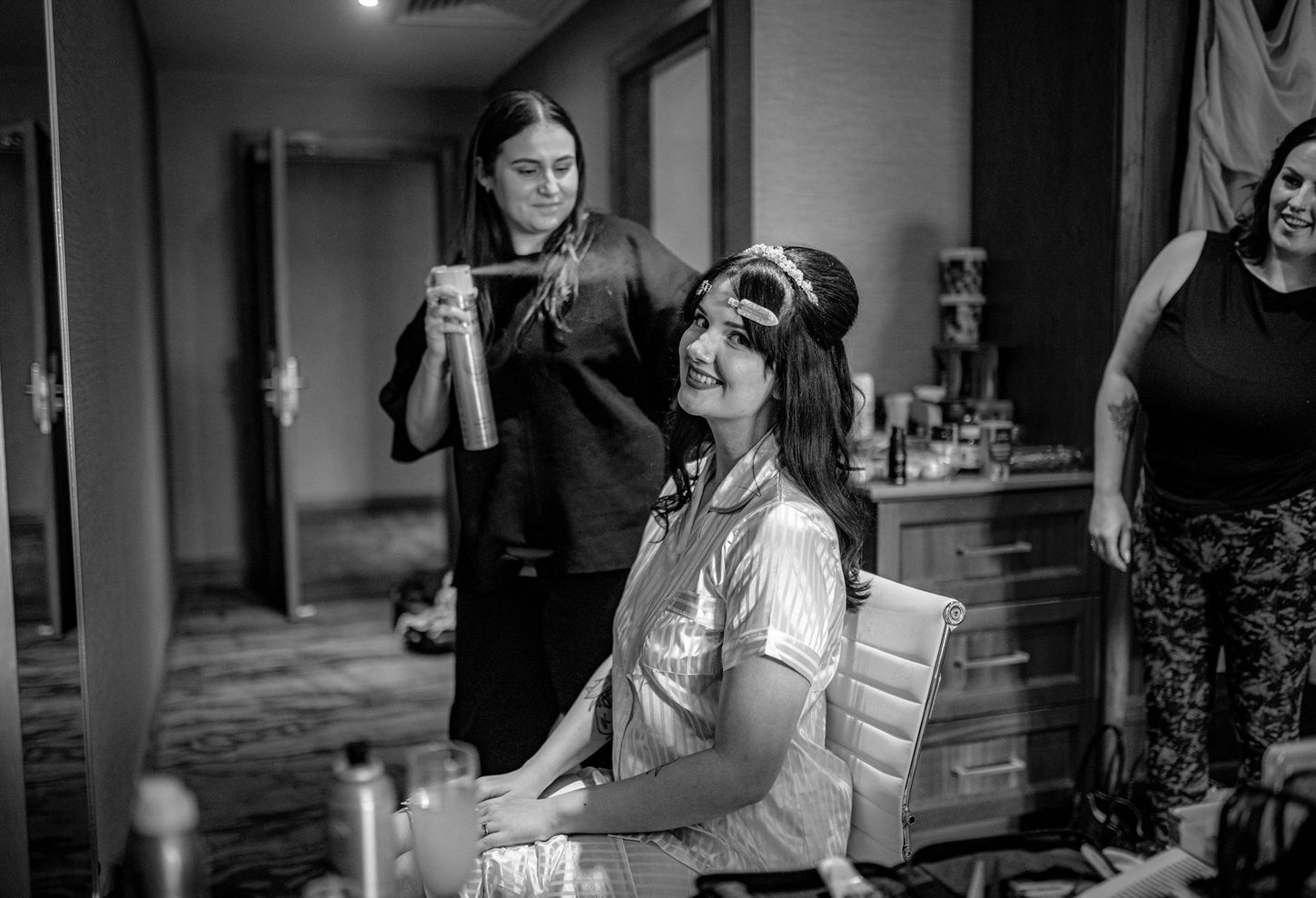 bride in PJ's having her hair set by hairdresser