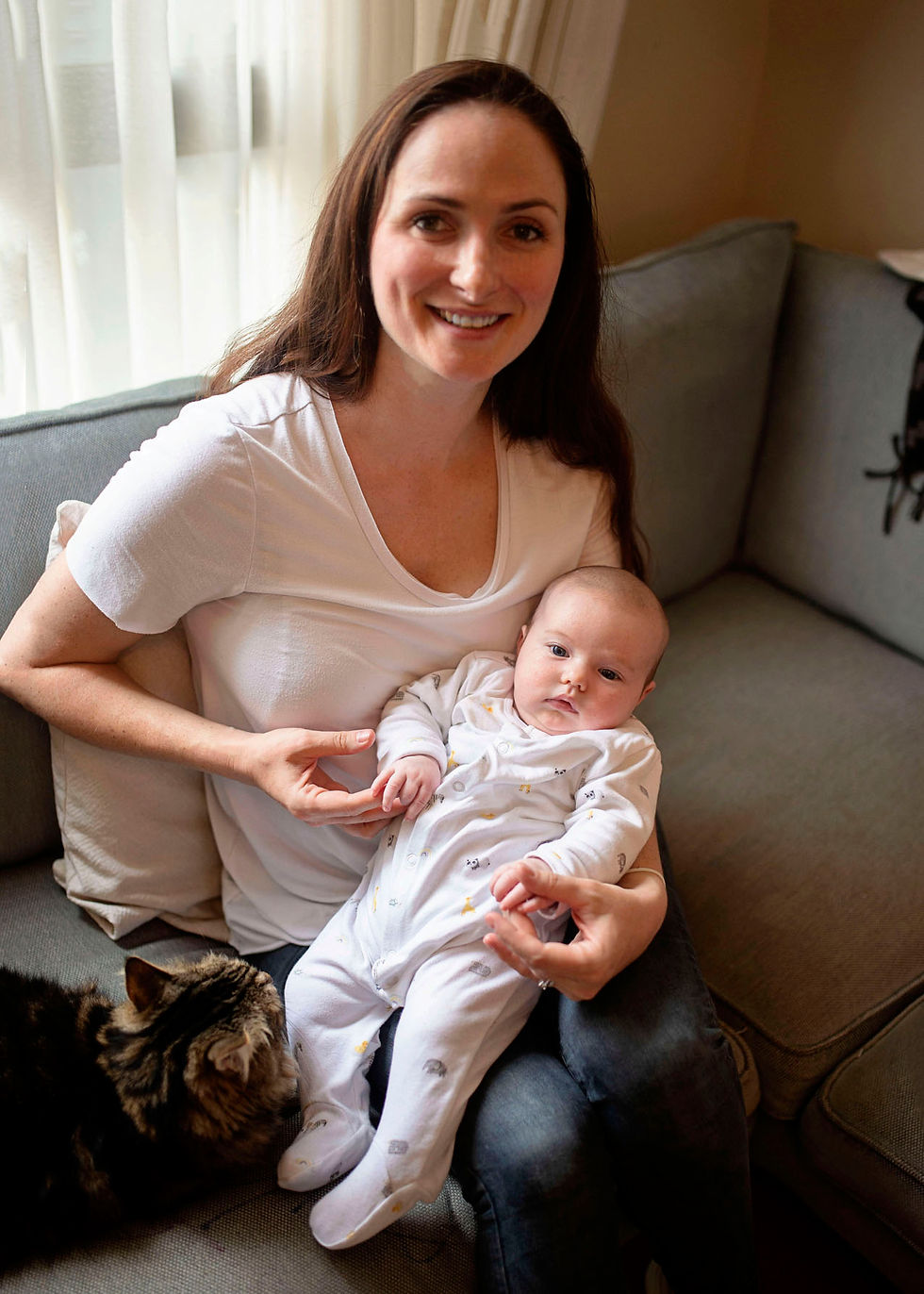 natural newborn at home dublin with mum holding newborn baby girl by window