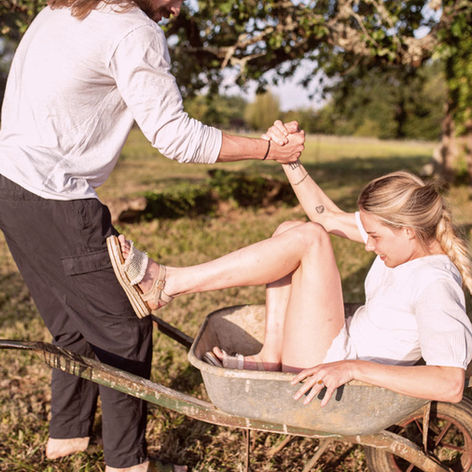 strong man's arms helping woman out of a wheelbarrow
