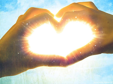 heart between fingers with light streaming through