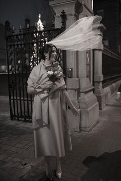 brides veil blowing in breeze under dramatic street lights at night