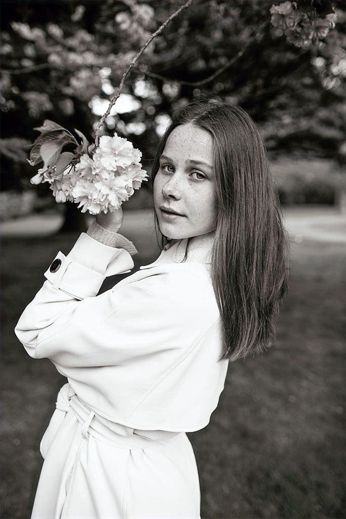 young woman reaching out for blossom, black & white portrait