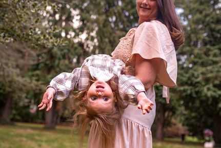 mum swinging baby daughter upside down and her hair flying