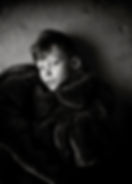 boy in fur coat with peaceful expression, child portrait, taken at home in window light