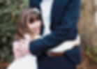 dad in smart suit hugging daughter in communion gown and hairband with flower at home in the garden