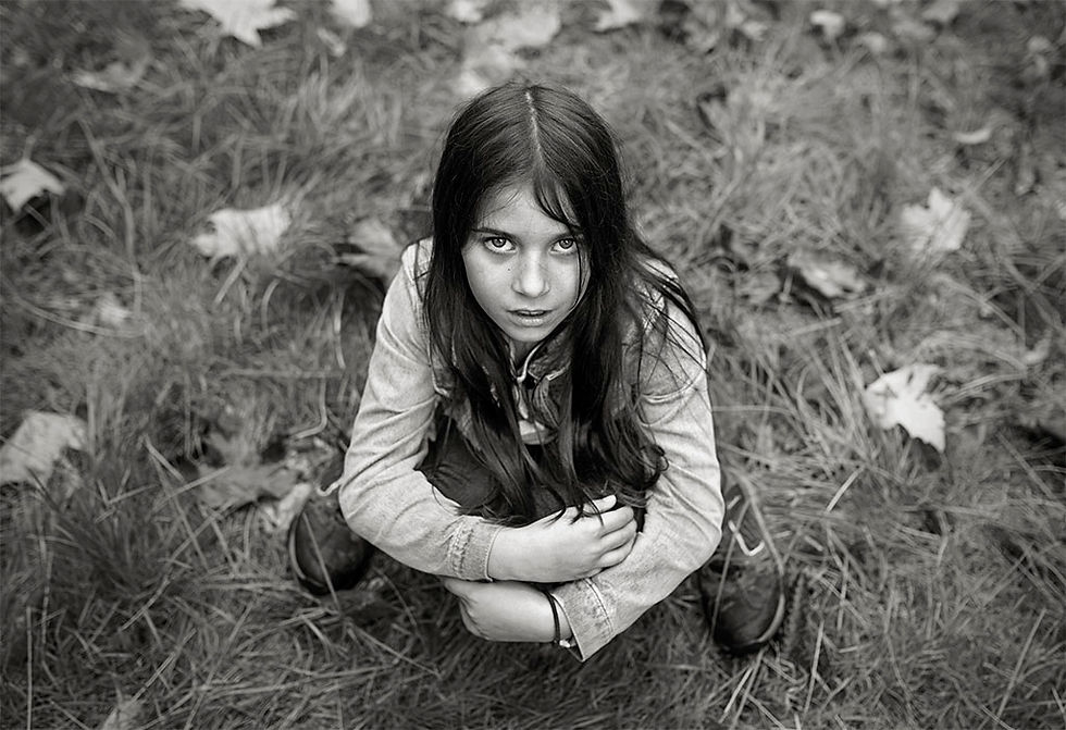 girl crouching in garden with intense expression