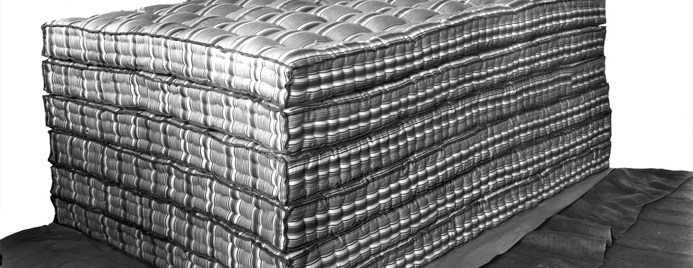 Stack of mattresses made at the Bellefontaine Mattress & Upholstering Co.