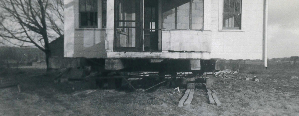 A house on rollers ready to be moved by Clarence Gibson