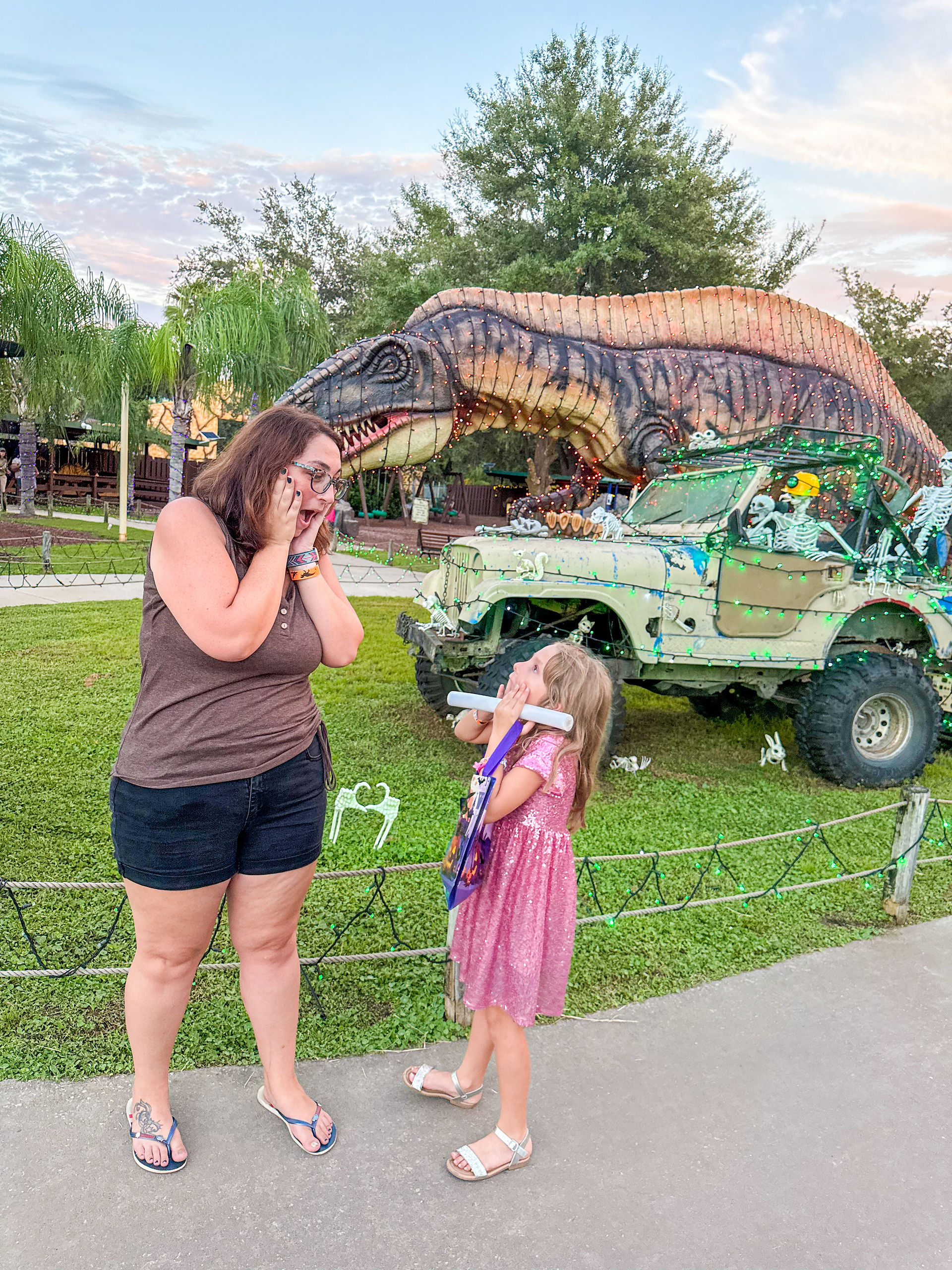 Us infront of Halloween decorations and dinosaur