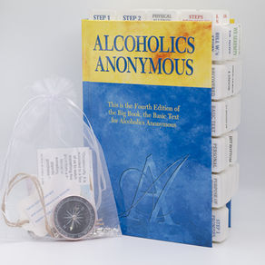 Tabbed AA Big Book with a gift bag and a compass