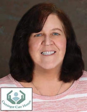 A white woman with dark hair and a big smile