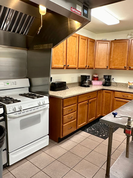 Kitchen with two stoves, counter space, many cupboards, and a metal island