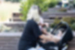 Thoughtful woman beside a wall with baby in car seat, representing life stages.