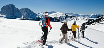 Escursione invernale: gruppo di persone con ciaspole in montagna