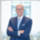 Dr. Bernd Egbers in einem professionellen Porträt, lächelnd in Anzug und Krawatte vor hellem Hintergrund.