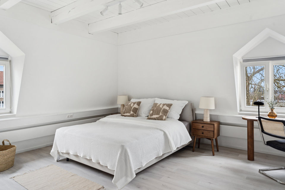 Weißes Schlafzimmer mit Doppelbett, Nachttischen und Blick auf Bodensee-Loft