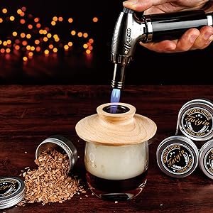 torch lighting wood chips into cocktail glass