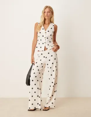 white in white and black polka dot vest and pants