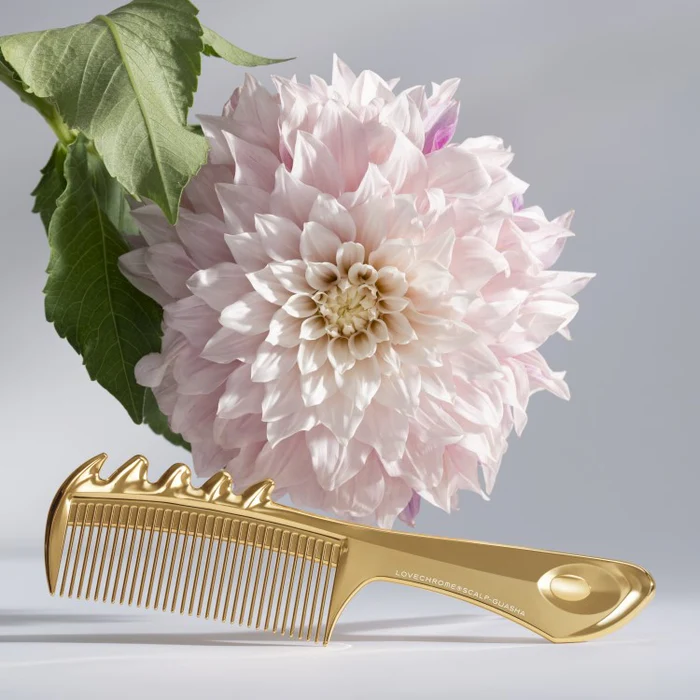 gold comb in front of pink flower