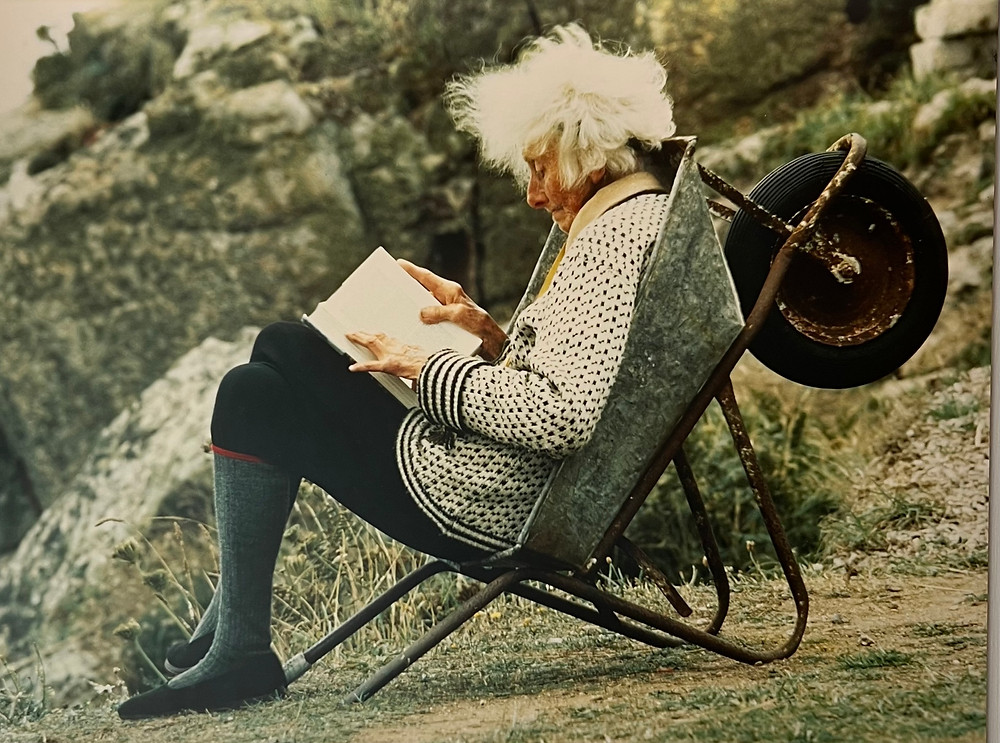 An old lady sitting in a wheel barrow