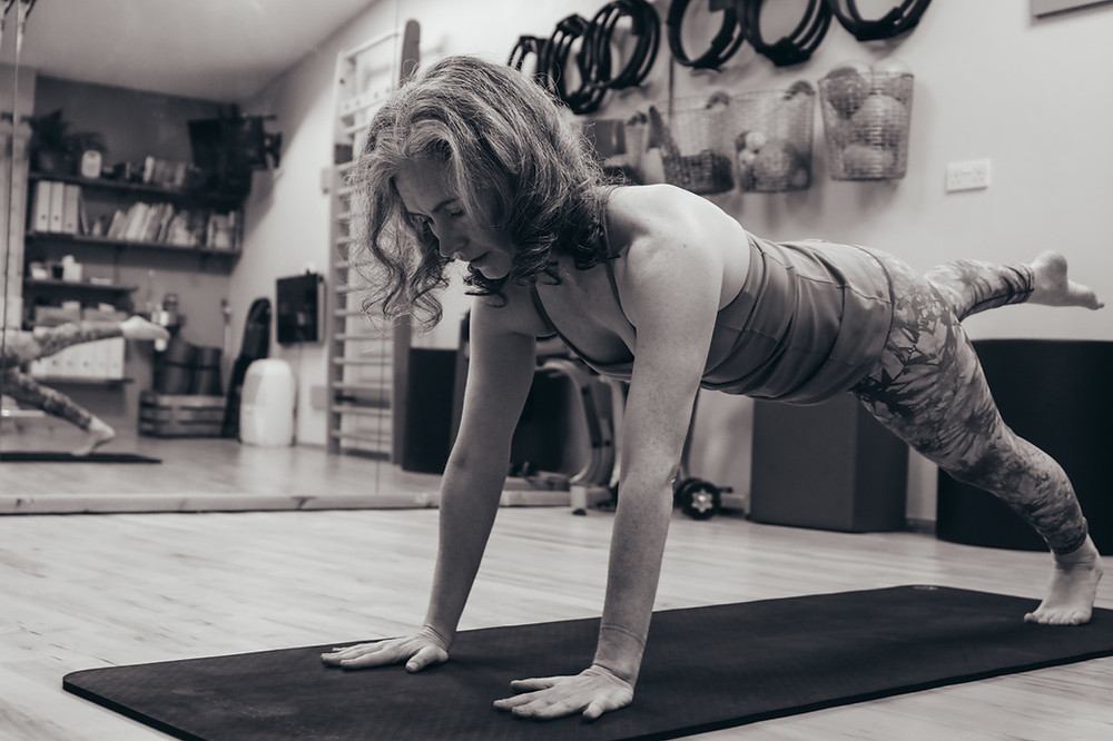 woman performing Pilates mat work exercise