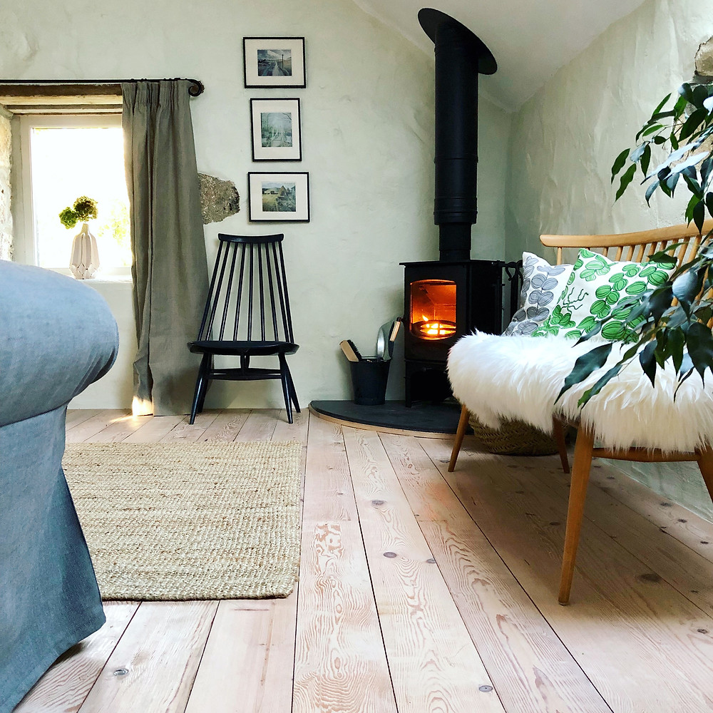 Mid-century furniture and a wood burning stove in Cornish cottage