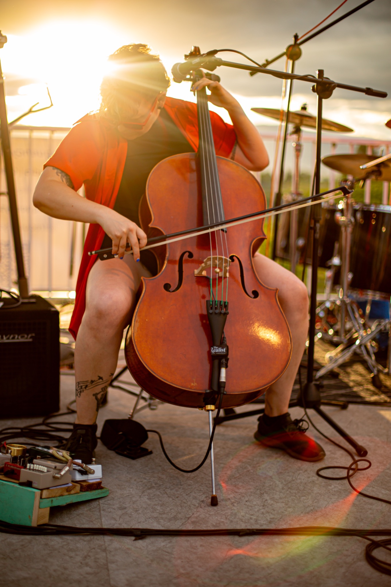 Cellist performing live at golden hour on an Okanagan outdoor concert stage, captured by Penticton commercial and lifestyle photographer Life Uncharted Studio