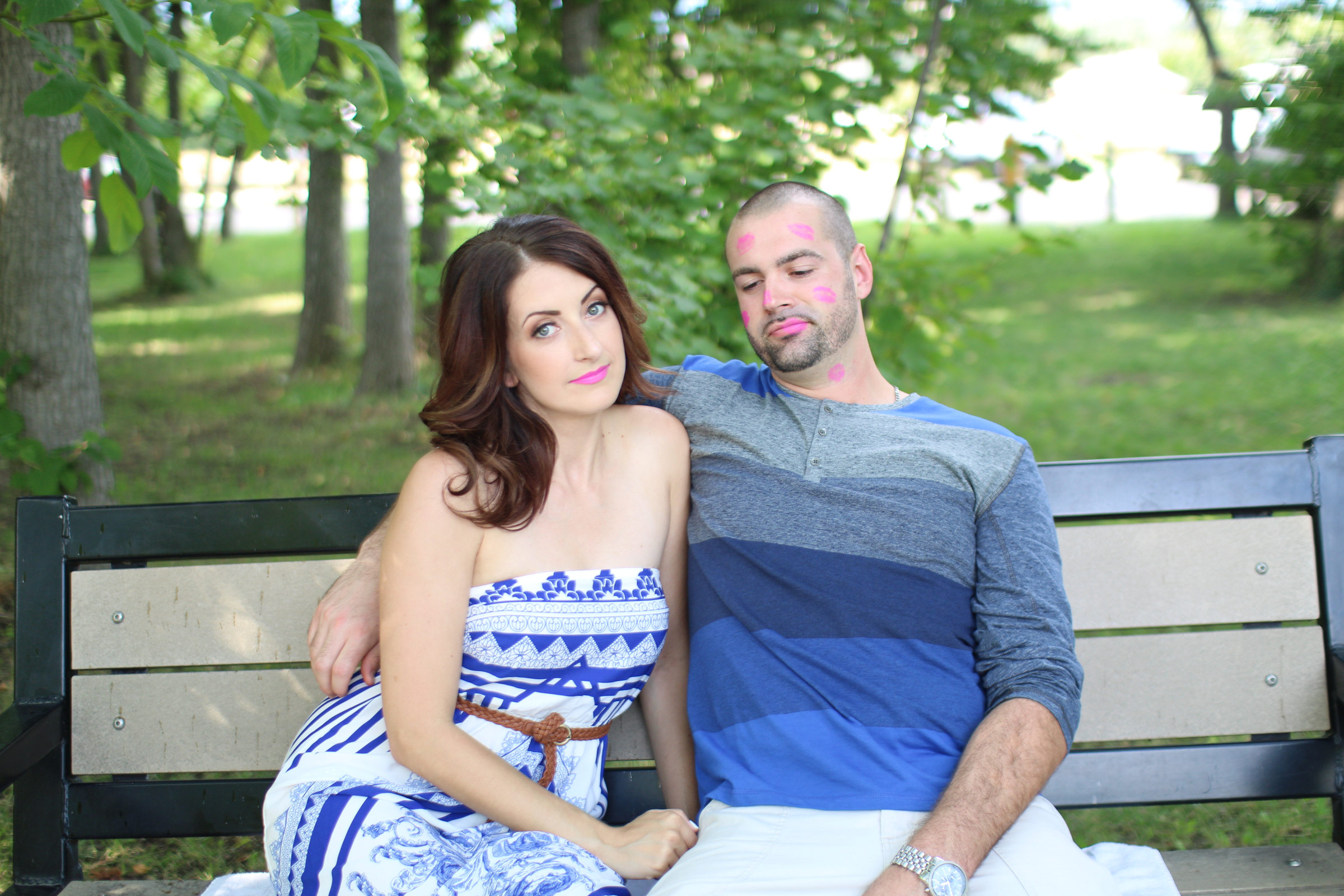 Lifestyle couples portrait of two people sitting close together on a garden bench