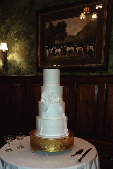 Romantic wedding cake design with large satin bow and clean buttercream finish by Hey Honey Cakery