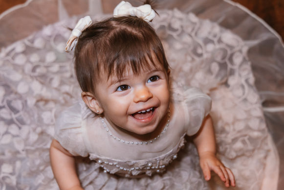 Menina feliz em vestido de festa, comemorando seu primeiro aniversário