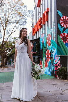 Mulher sorri para foto no dia do seu casamento em frente ao verde durante o dia