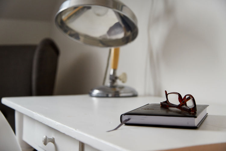 Brillen und Notizbuch auf weißem Schreibtisch