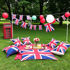 create a UK themed kids party with the setting out on grass in a park. no chairs only cush