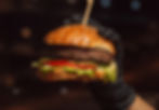 hand-burger-gloves-holding-beef-burger-black-background (1)_edited.jpg
