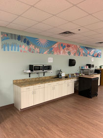 picture of a kitchen with long wall graphic showing plants, ingredients, and cooking food.