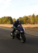 Motorcyclist in gear riding on a highway for photography