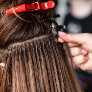 Extension expert Hannah applying Keratin Bond extensions to brown hair. 