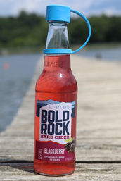 Bold Rock Cider bottle with Swig Essentials reusable bottle cap on a wooden dock
