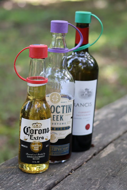 Beer, Whiskey and Wine Bottle on picnic table with Swig Essentials reusable bottle caps